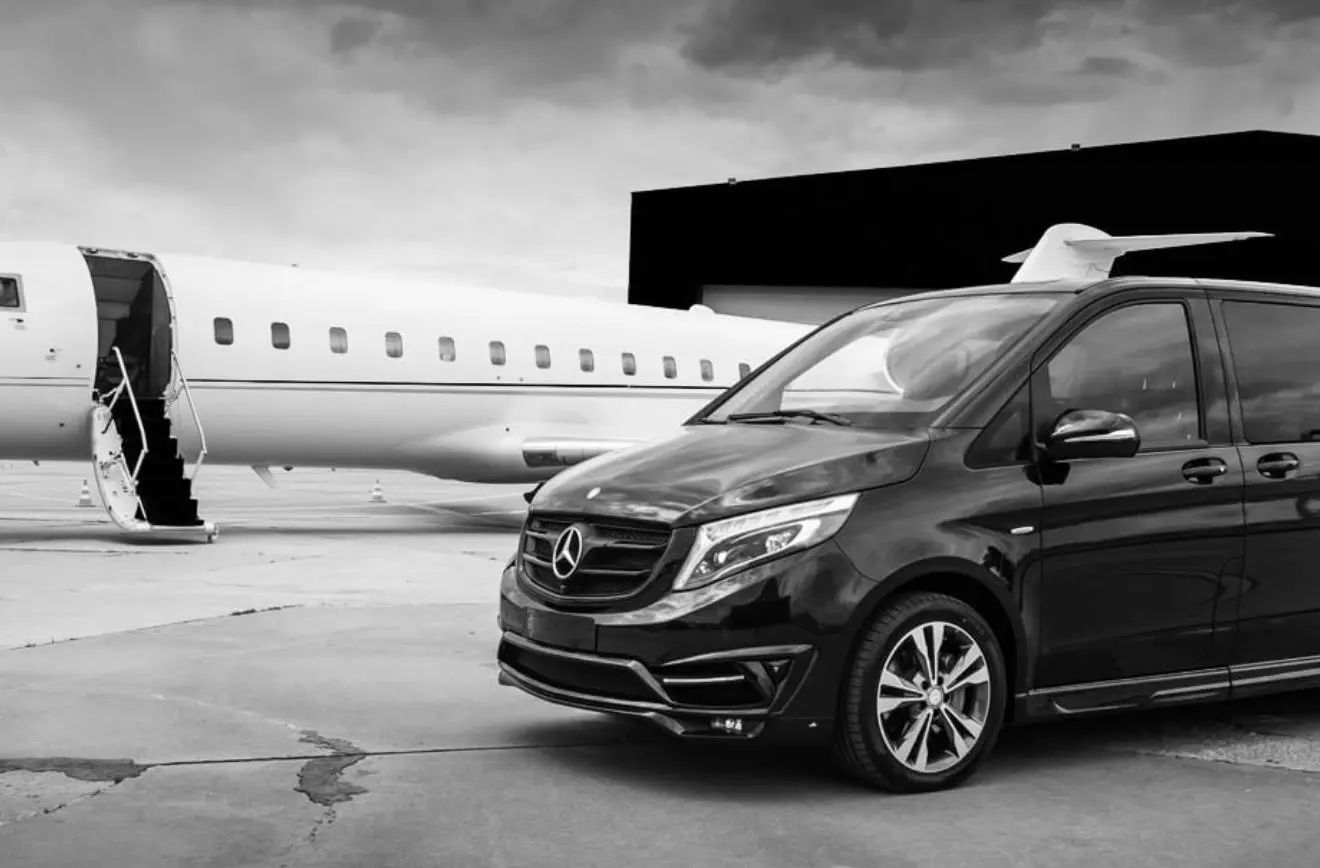 Chauffeur professionnel devant un taxi van 8 places à Paris pour transport de groupe